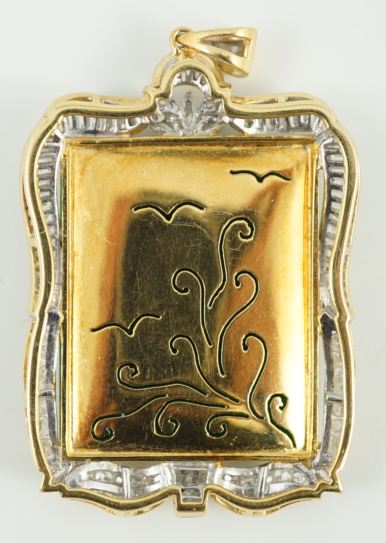 A late 20th century gold (tests as 18ct) mounted jade pendant, with round, marquise and trapeze cut diamond set border